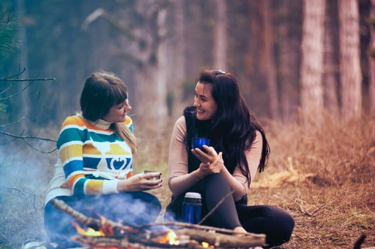 Two women talking by a fire